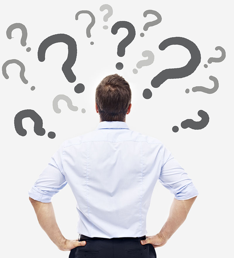 Business Person Looking at Many Question Marks