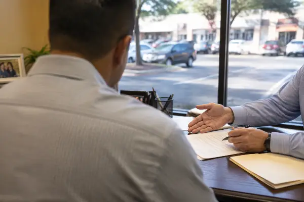 Cliente y agente de seguros en una oficina de Houston revisando una póliza