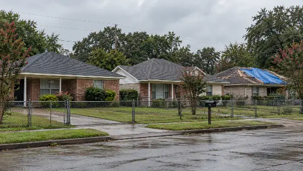 Casas de Houston con techos nuevos y una con lona esperando reparación
