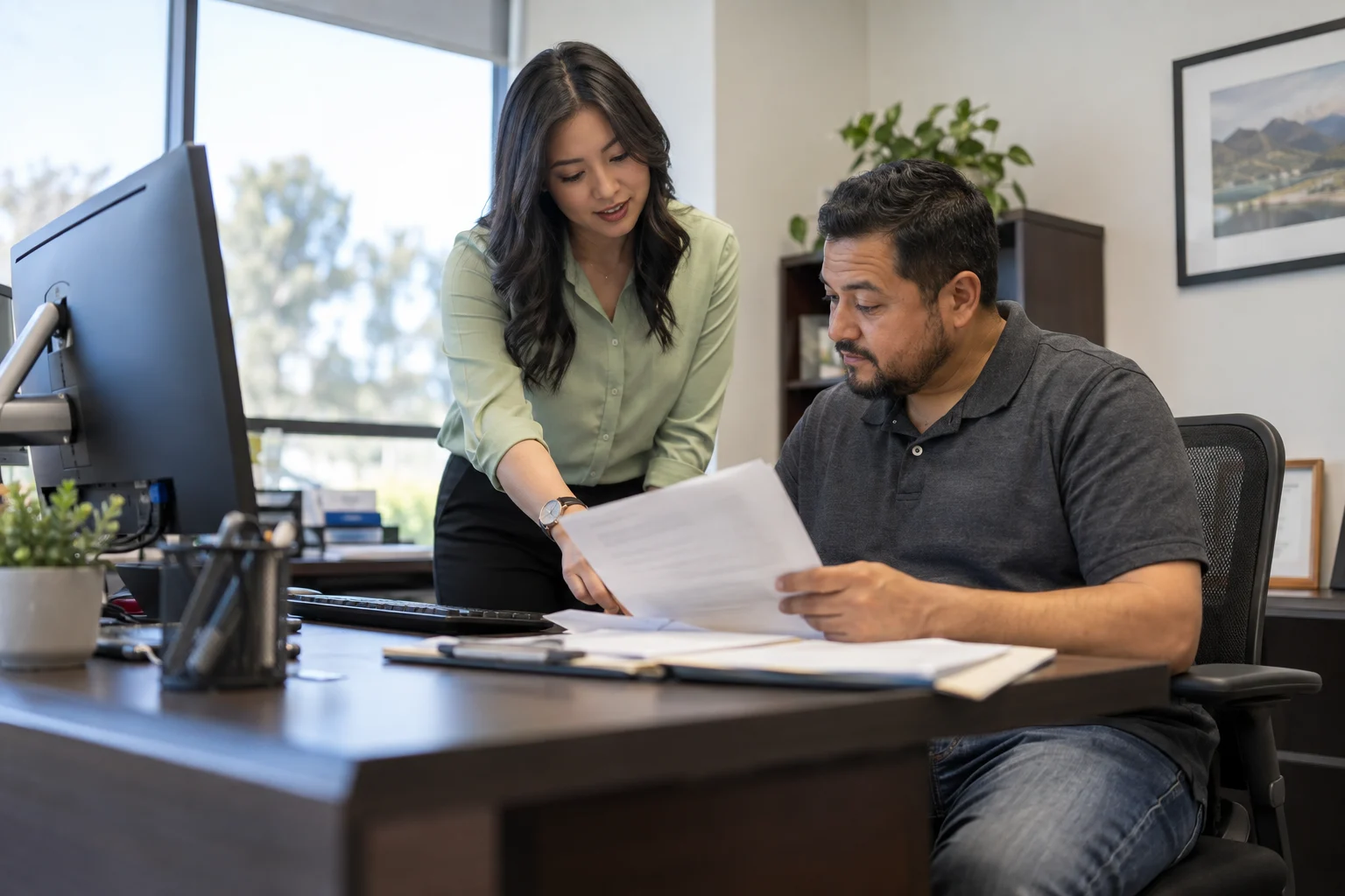 Asesora revisando documentos de seguro familiar con un cliente